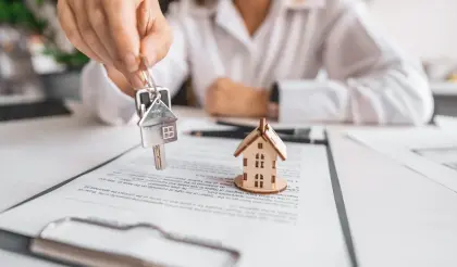 Asesor inmobiliario revisando con su cliente los documentos de una compraventa