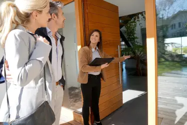 Asesor inmobiliario independiente mostrando una casa a sus clientes